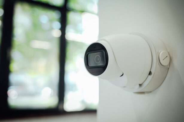 White wall-mounted smart home security camera monitoring a bright window